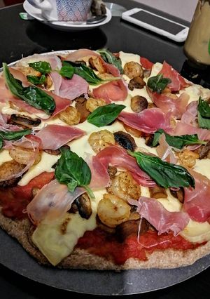 Una foto de Pizza integral con jamón serrano, camarones