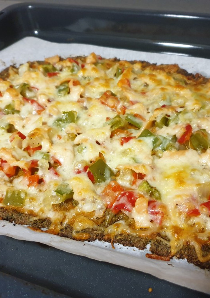 Una foto de Pizza con base de brócoli y nueces con verduras y salmón ahumado