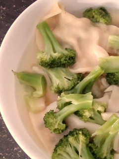 A picture of Brocolli and Dumpling Soup.