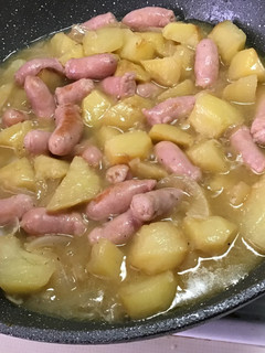 Una foto de Patatas fritas con salchichas frescas encebolladas al vino