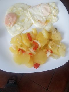 Una foto de Papas a lo pobre con huevo frito