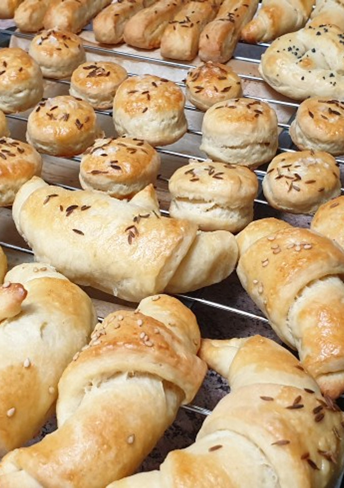 Una foto de Saladitos hojaldrados (Tejfölös pogácsa, tangli es kifli)