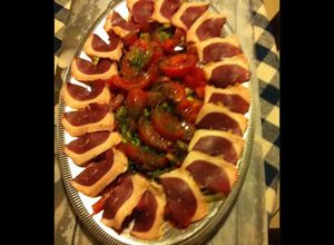 Une photo de Salade de tomates aux magrets de canard fumés oignons nouveaux et herbes