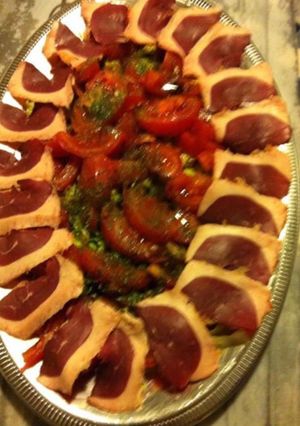 Une photo de Salade de tomates aux magrets de canard fumés oignons nouveaux et herbes