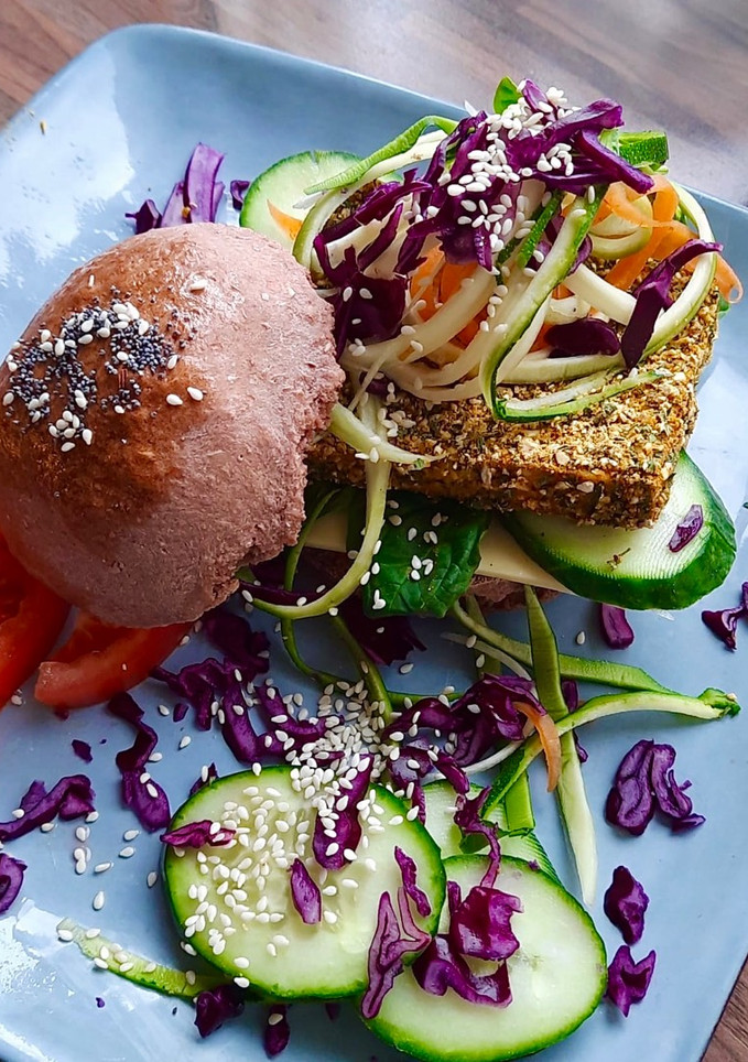 Una foto de Hamburguesa vegana de tofu rebozado en especias con pan de remolacha