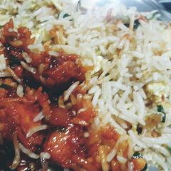 A picture of Fried rice with orange chicken.