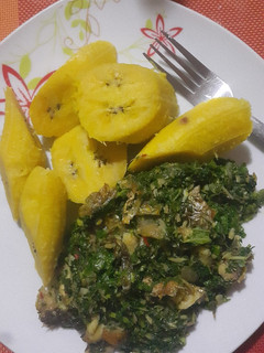 A picture of Boiled semi riped plantain with ugu sauce.