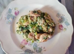 Una foto de Dados de pollo al verdeo con ensalada de lechuga, cebolla y brotes de lentejas