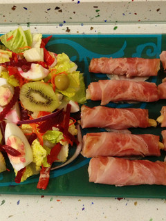Una foto de Rollitos de lacón ahumado con espárragos y ensalada de colores