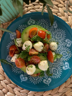 Una foto de Aguacates con tomate cherry, perlas de mozzarella, rúcula y orégano