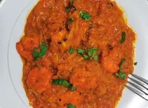 Una foto de Zucchini con camarones cocidos en salsa de tomate