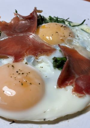 Una foto de Huevos rotos con espárragos silvestres y jamón