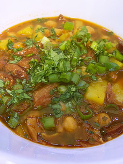 A picture of Spanish bean soup with smoked sausage and potato.