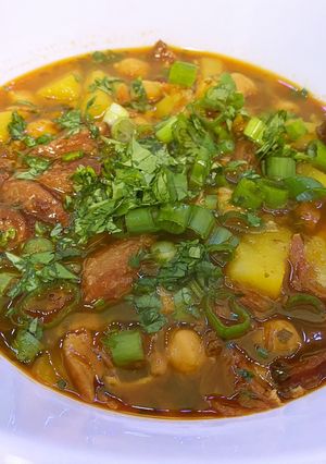 A picture of Spanish bean soup with smoked sausage and potato.