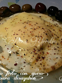 Una foto de Huevo frito, con queso en lonchas y hiebas aromáticas