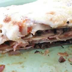 Una foto de Lasagna de espinaca, carne, jamón y queso