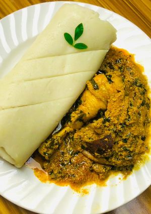 A picture of Egusi soup and rolled up pounded yam.