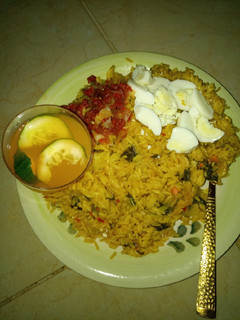 A picture of Jollof rice macaroni boiled egg en sauce and mango juice.