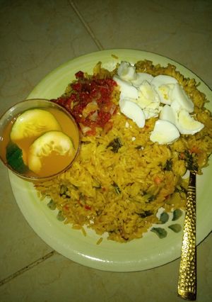 A picture of Jollof rice macaroni boiled egg en sauce and mango juice.