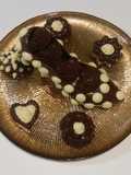 Bombón de chocolates belgas abrazados con bergamota y nueces de macadamia