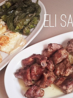 Una foto de Costillas asadas con papas a la cerveza, huevo frito y pimientos cuerno cabra fritos