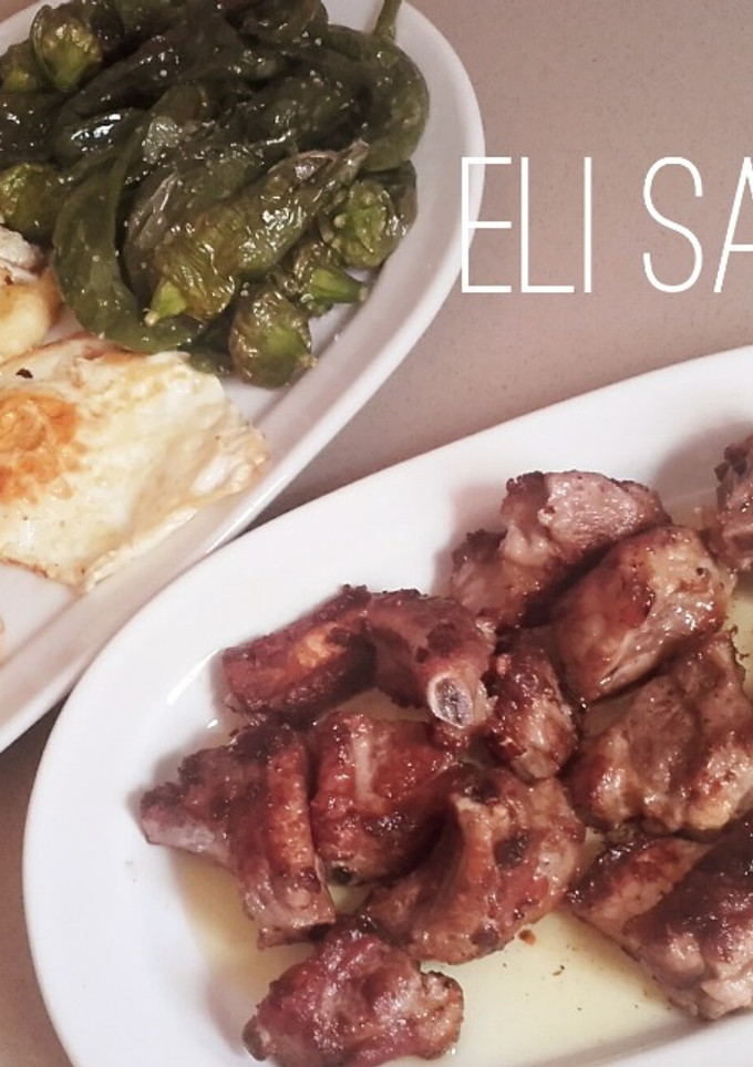 Una foto de Costillas asadas con papas a la cerveza,  huevo frito y pimientos cuerno cabra fritos