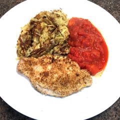 A picture of Pork Snitzel with Pan Fried Rosti & Tomato.
