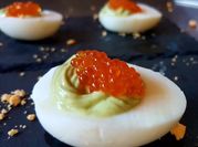 Una foto de huevos rellenos con caviar