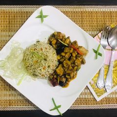 A picture of Kung pao chicken with egg fried rice.