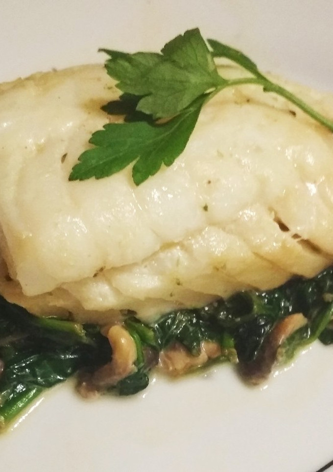 Una foto de Bacalao sobre cama de espinacas y champis