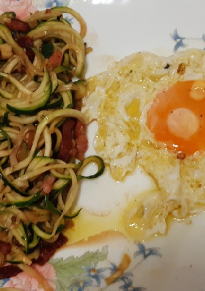 Una foto de Huevo frito y espaguetis de calabacín al ajillo con bacon