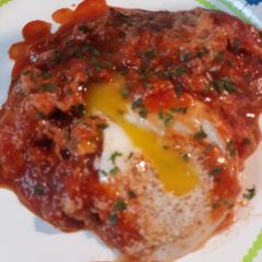 A picture of Chorizo and Eggs in a Cheesey Tomato Sauce.