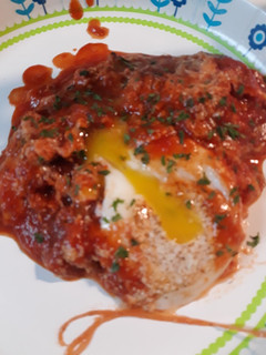 A picture of Chorizo and Eggs in a Cheesey Tomato Sauce.