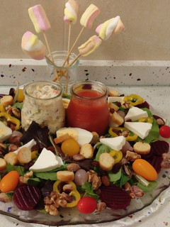 Una foto de Ensalada de brotes con ensaladilla rusa, sopa de tomate, frutos secos y esponjas dulces