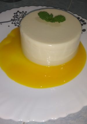 Una foto de Panna cotta con Coulis de mango