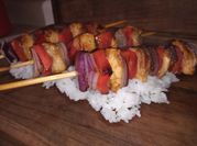Una foto de brochetas con salsa teriyaki