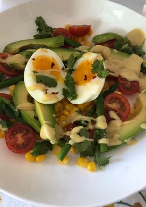 A picture of Asparagus, sweet corn, avocado and soft boiled egg salad.