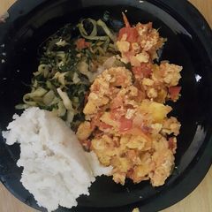 A picture of Scrambled eggs served with ugali and vegetables.