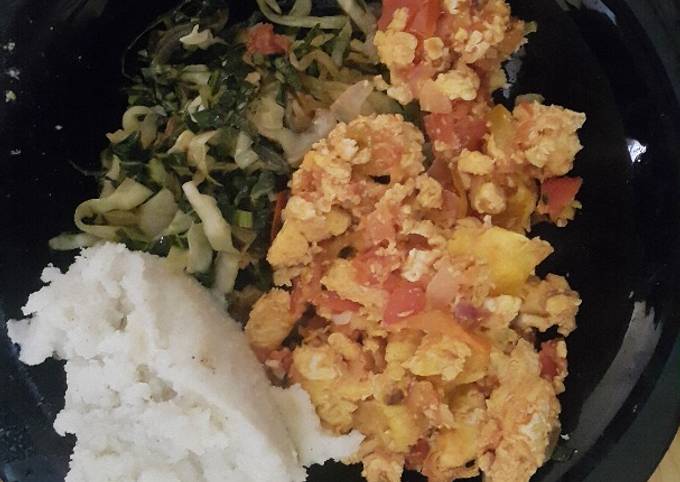 Scrambled eggs served with ugali and vegetables