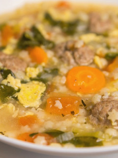 A picture of Italian wedding soup with meatballs.
