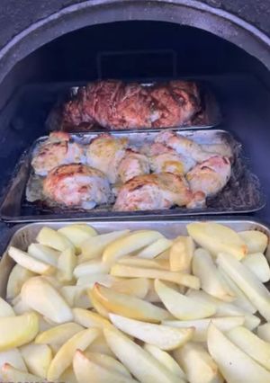 Una foto de Papas horneadas con chuletas y pollo asado