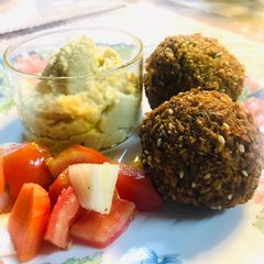A picture of Falafel with hummus and veggies.