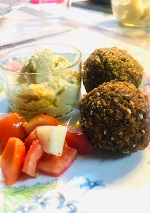 A picture of Falafel with hummus and veggies.