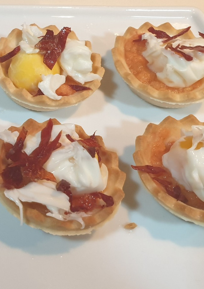 Una foto de Tartaletas de huevo poché de codorniz con crujiente de jamón