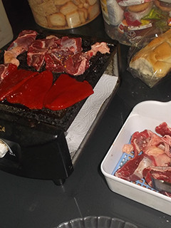 Una foto de Cocinando carne en la mesa