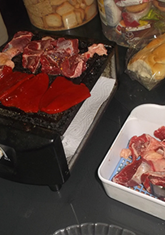 Una foto de Cocinando carne en la mesa