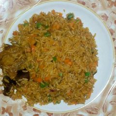 A picture of Jollof rice garnish with green pepper green peas and carriot.