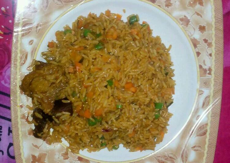 Jollof rice garnish with green pepper green peas and carriot