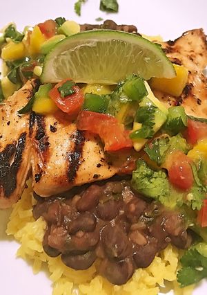 A picture of Island chicken with beer braised black beans and yellow rice.