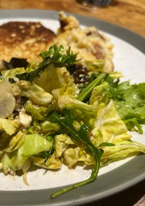 A picture of Savoy cabbage and green leaves salad with tasty dressing.